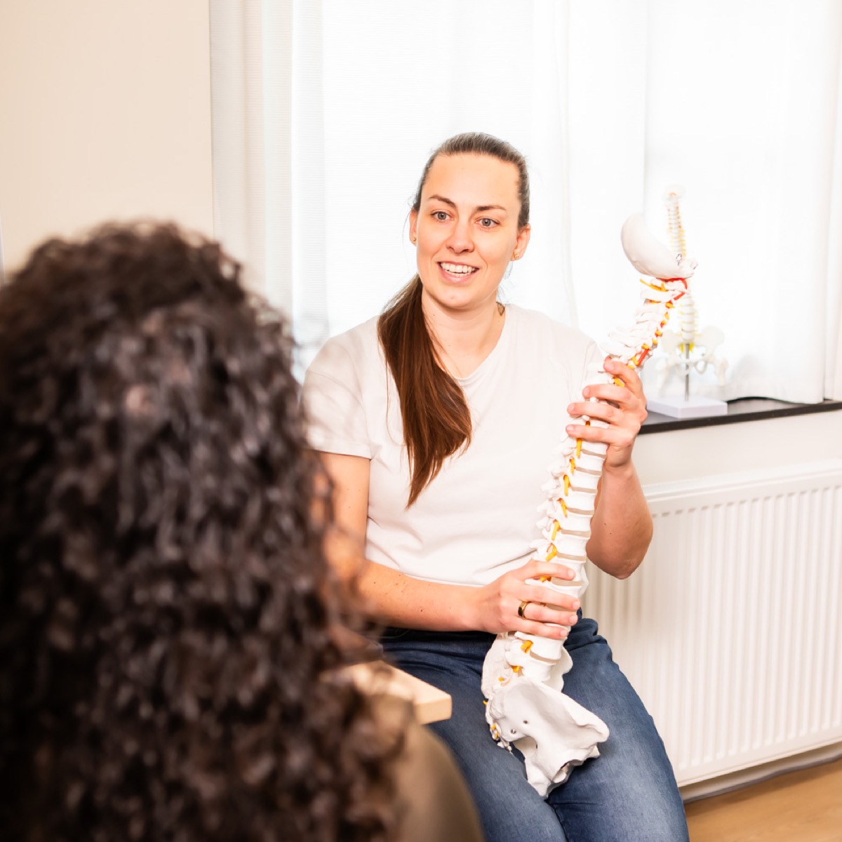 Chiropractor bespreekt het persoonlijke zorgplan met een cliënt bij TOPCHIRO Amstelveen